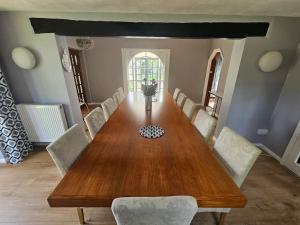 a dining room with a wooden table and chairs at English Farmhouse Cottage in Guildford