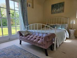 a bedroom with a bed and a couch and a window at English Farmhouse Cottage in Guildford