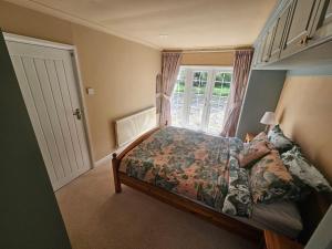 a bedroom with a bed and a window at English Farmhouse Cottage in Guildford