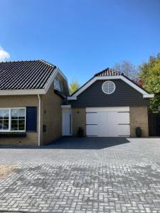a house with a garage and a driveway at Duinstrand Burgh-Haamstede in Burgh Haamstede