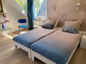 sypialnia z 2 łóżkami, krzesłem i oknem w obiekcie Park View Apartment w Amsterdamie