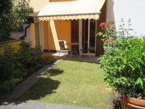 a garden with a table and awning on a house at Casa Speranza PT in Muralto