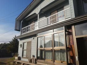 a house with a balcony on top of it at Yukiumi House in Kamikawa