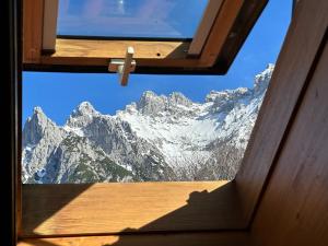 a view of a snow covered mountain from a window at Ferienwohnung Seidl Wohnung Violine in Mittenwald