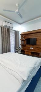 a bedroom with a bed and a tv on a dresser at Hillview 2BHK Flat in Dehradun in Dehradun