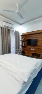 a bedroom with a bed and a tv on a dresser at 2BHK Luxury apartment in Dehradun in Dehradun +55 photos