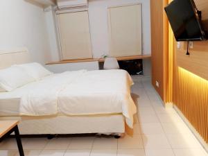- une chambre avec un lit et une télévision à écran plat dans l'établissement Nusantara Rooms By Reccoma, à Bulanbulan