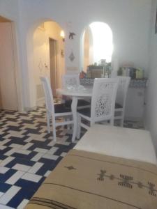 a dining room with a white table and chairs at Bel appartement au coeur du Port El Kantaoui in Port El Kantaoui