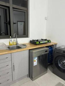 a kitchen with a sink and a washing machine at Comfy 2-Bedroom Apt, 10mins Walk to Beach - GBHC5 in Grand Baie
