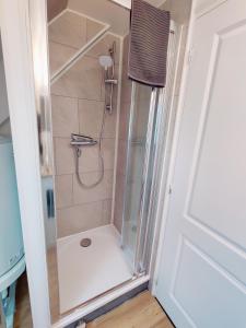 La salle de bains est pourvue d'une douche avec une porte en verre. dans l'établissement Maison 30m2 - 1 chambre - Jardin, à Fontaine-Étoupefour