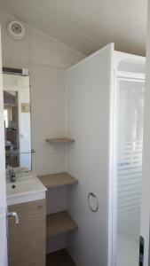 Baño pequeño con lavabo y espejo en bungalow jardim bonito 11zz en Pataias