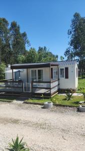 una casa mobile con veranda su un vialetto di ghiaia di bungalow jardim bonito 11zz a Pataias