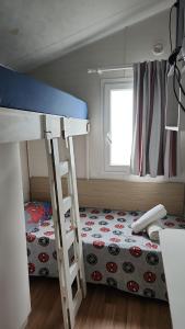 a bedroom with a bunk bed and a ladder at bungalow jardim bonito 11zz in Pataias