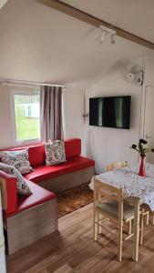 uma sala de estar com um sofá vermelho e uma mesa em bungalow jardim bonito 11zz em Pataias