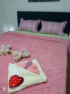 un letto rosa con due letti con cuscini rosa di Apartman LARA a Pirot