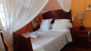 a white cat laying on a bed in a bedroom at Holiday Home Villa Kay Malouz in Saint-Joseph