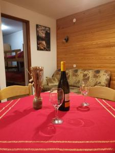 uma garrafa de vinho sentada numa mesa com dois copos em Apartment Doris Mrkopalj em Mrkopalj