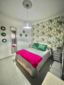 a bedroom with a large bed with a pink blanket at Teror Centro 1 in Teror