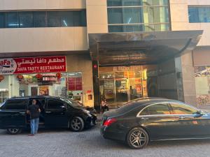 two cars parked in front of a building at Ft 22 R1 Luxury Room attach bath Seaview Beach access Ajman غرفة فاخرة مع إطلالة على البحر وإمكانية الوصول إلى الشاطئ in Ajman 