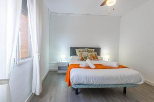 コルドバにあるApartamento Cordoba Miaの白いベッドルーム(オレンジ色の毛布付きのベッド付)