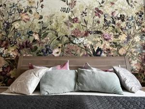 um quarto com um papel de parede floral e uma cama com almofadas em Karli‘s Plätzchen em Gera