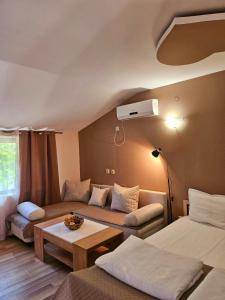 ein Wohnzimmer mit 2 Betten und einem Sofa in der Unterkunft Orehite-Family Hotel ,Food & Pool in Bozhichen