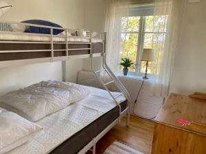 a bedroom with two bunk beds and a window at Nära Kvarnen-Mollösund in Mollösund