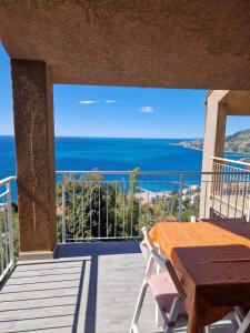 a balcony with a table and a view of the ocean at La finestra sul golfo in Ospedaletti