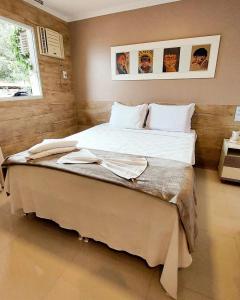 a bedroom with a large bed with white sheets at Tapindaré Hotel in Alto Paraíso de Goiás