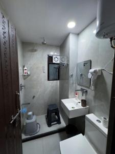 ein kleines Bad mit einem Waschbecken und einer Dusche in der Unterkunft Casa Paradis- secure, cozy& peaceful paradise in heart of most happening colony in Jaipur