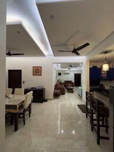 uma sala de jantar e sala de estar com mesa e cadeiras em Casa Paradis- secure, cozy& peaceful paradise in heart of most happening colony em Jaipur