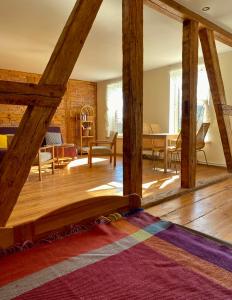 a living room with wooden beams and a dining room at Stara Szkoła na Warmii in Mokiny