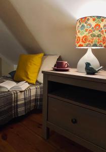 a bedroom with a bed with a lamp and a book at Stara Szkoła na Warmii in Mokiny