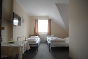 a room with two beds and a table and a window at Motel u Olka in Boczów