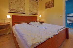 a large bed in a bedroom with two pillows on it at Seegang- Fewo mit Grundstück in Flessenow +12 photos