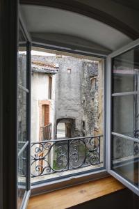 ventana con vistas a un edificio antiguo en Le Repose Pieds, en Le Monastier sur Gazeille