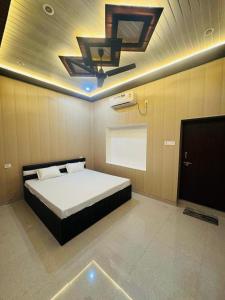 1 dormitorio con 1 cama y ventilador de techo en Dev Villa, en Varanasi