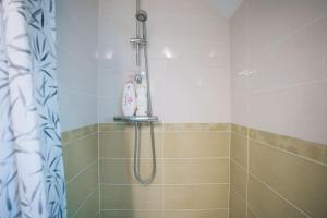 La salle de bains est pourvue d'une douche avec un pommeau de douche. dans l'établissement Le Beaumont • La Belle Campagne • La Plénitude, à Déols