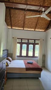 a bedroom with a bed in a room with windows at White house Sumatra Bukit Lawang in Timbanglawang