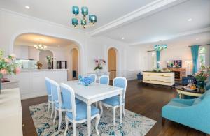 a dining room with a white table and blue chairs at Villa Hạng Sang Đà Lạt - Gần Hồ Xuân Hương Gần Chợ Đà Lạt in Xuan An