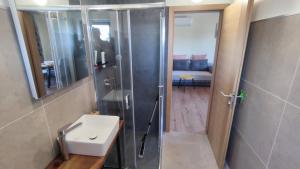 a bathroom with a shower and a white sink at Modern apartment in Biograd na Moru +14 photos