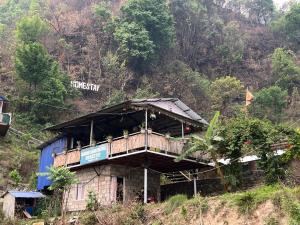 ein Gebäude mit einer Terrasse auf einem Berg in der Unterkunft Langhali Agricultural Homestay in Pokhara