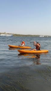 Dahabiya Nile Sailing - Mondays 4 Nights from Luxor - Fridays 3 Nights from Aswan في الأقصر: شخصان في الزوارق على هيئة مياه