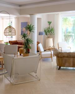 a living room with white furniture and plants at Hotel Piccolo Mondo in Lido di Camaiore