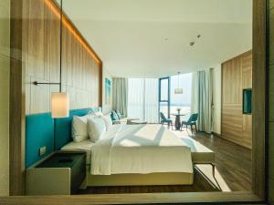 a hotel room with a large bed and a desk at Alacarte- Rosabella Nguyen in Ha Long