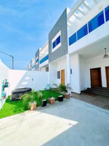 a white house with potted plants in front of it at Charly-duplexben in Cotonou