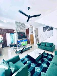 a living room with green couches and a ceiling fan at Charly-duplexben in Cotonou