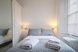 1 dormitorio con 1 cama con toallas en 7 Mount Sion, en Royal Tunbridge Wells