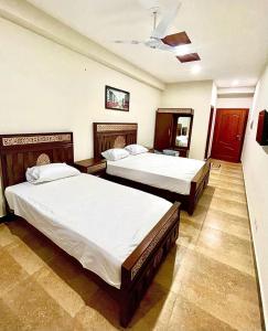 um quarto com 2 camas e um tecto em Faisal Lodges em Islamabad