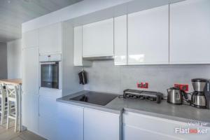 uma cozinha com armários brancos e um lavatório em Grande maison 3 chambres em Maisons-Alfort